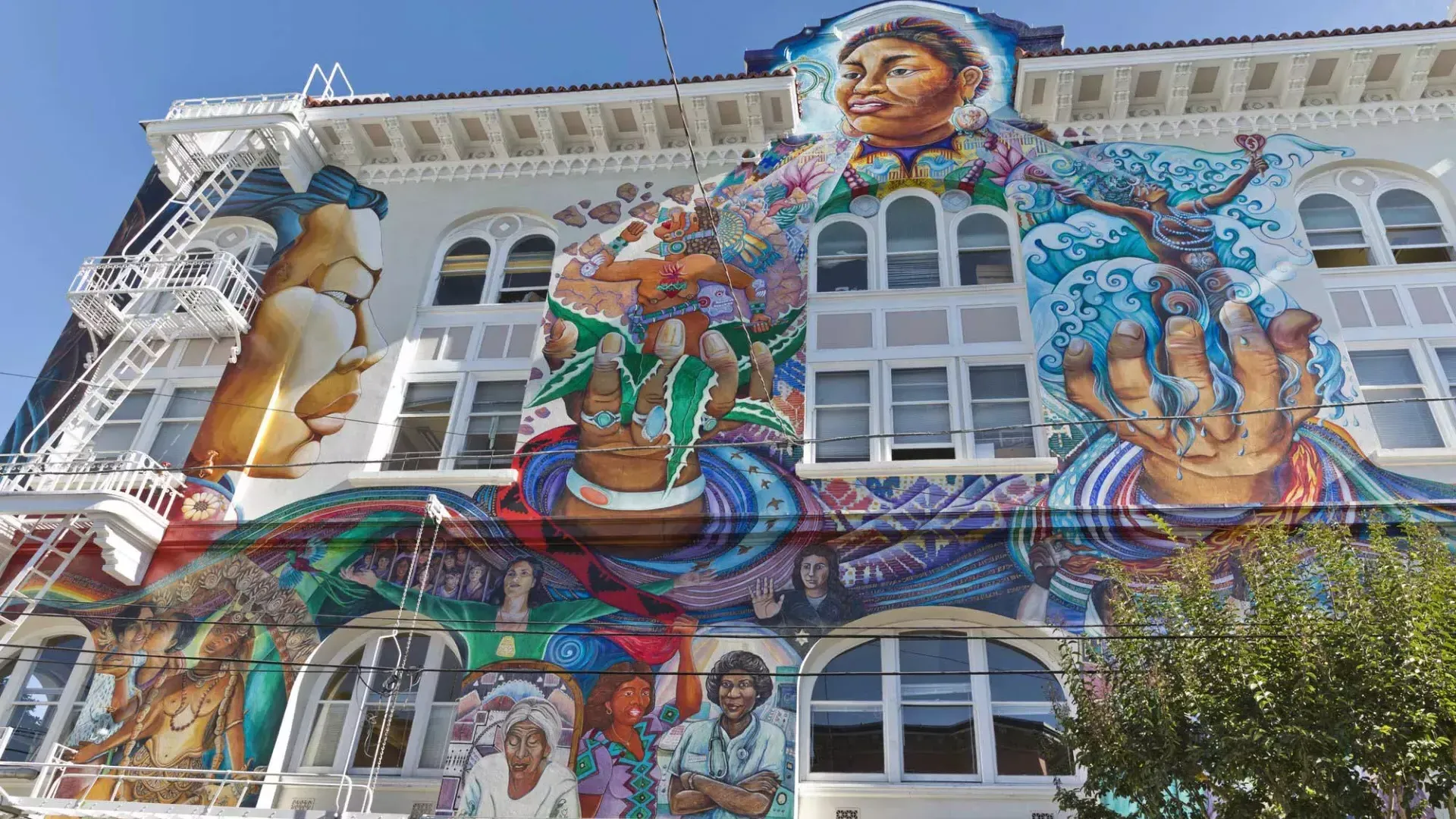 Une fresque murale colorée à grande échelle recouvre le côté du Women's Building dans le Mission District de San Francisco.