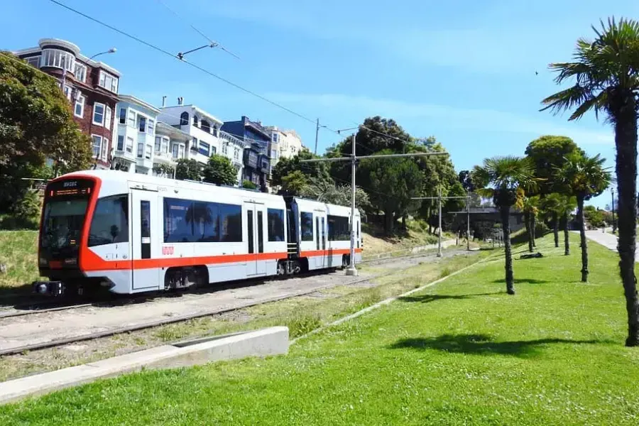 Un train de voyageurs MUNI circule sur une voie ferrée à San Francisco.